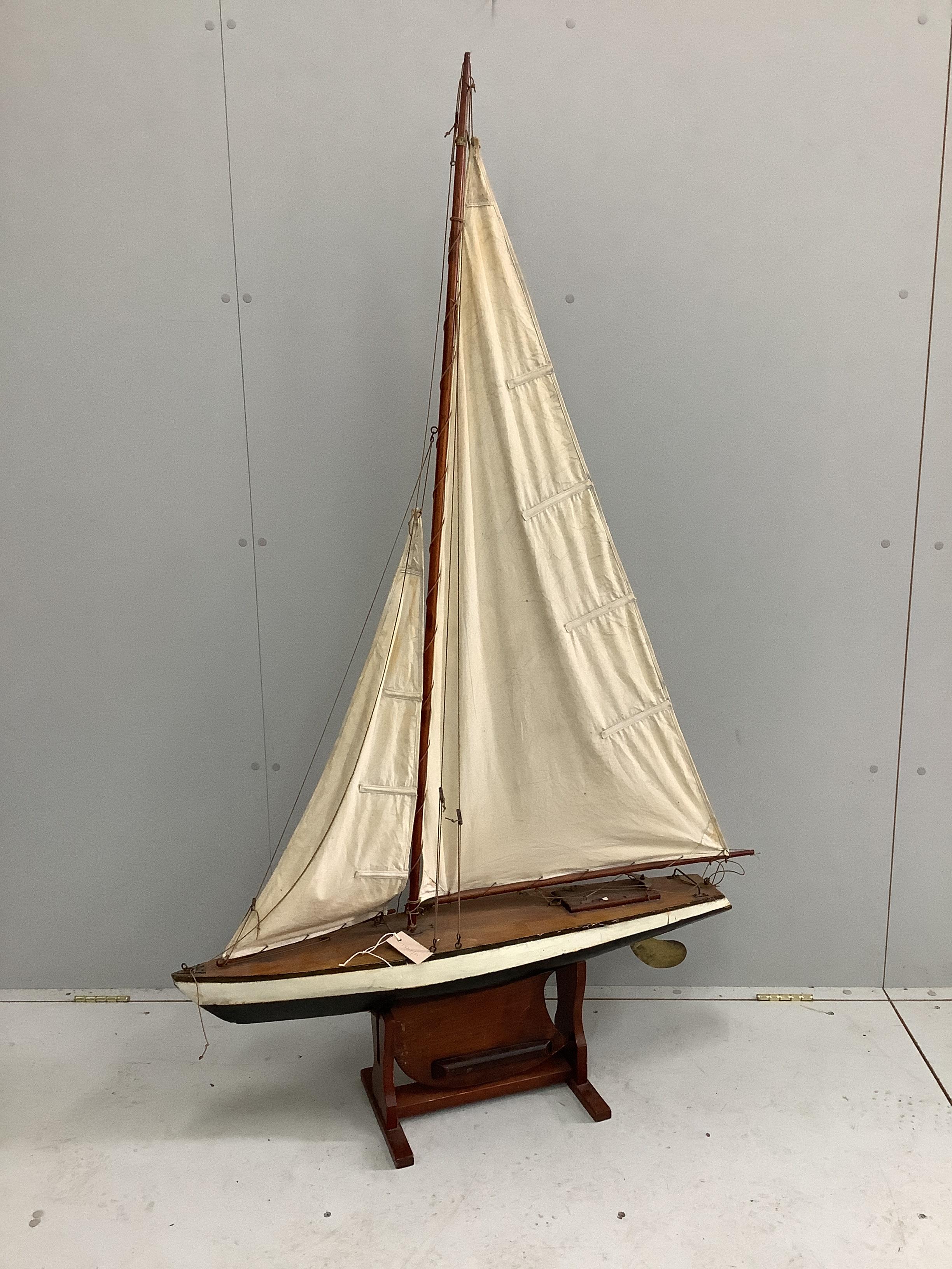 A vintage pond yacht with weighted hull and brass rudder, width 95cm, height with stand 166cm